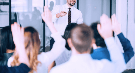 A trainer leading a workshop session with employees actively participating, showcasing an organized training program with visual aids, notes, and a projector, emphasizing skill development and collaboration.